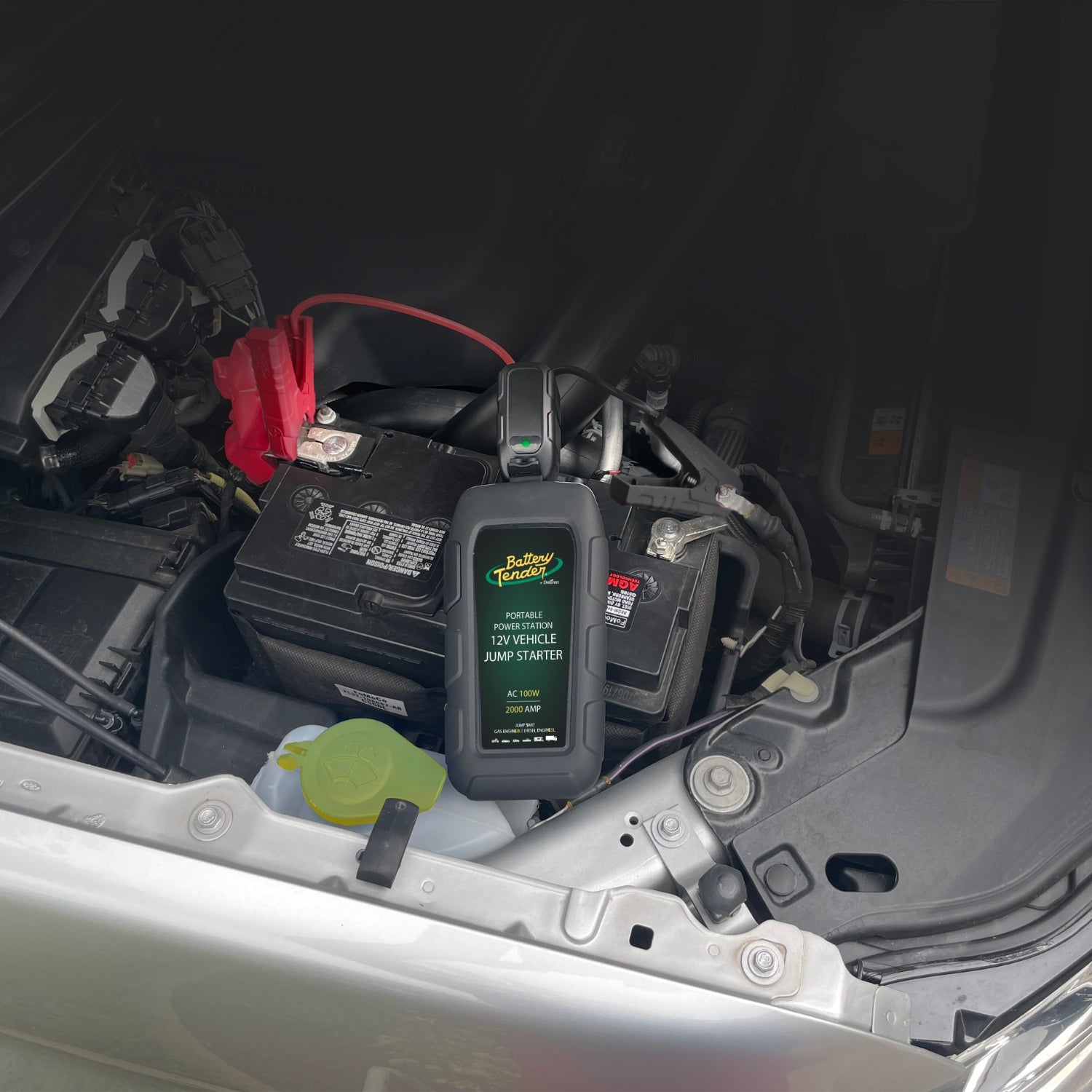 A Battery Tender jump starters sits on top of a car battery.